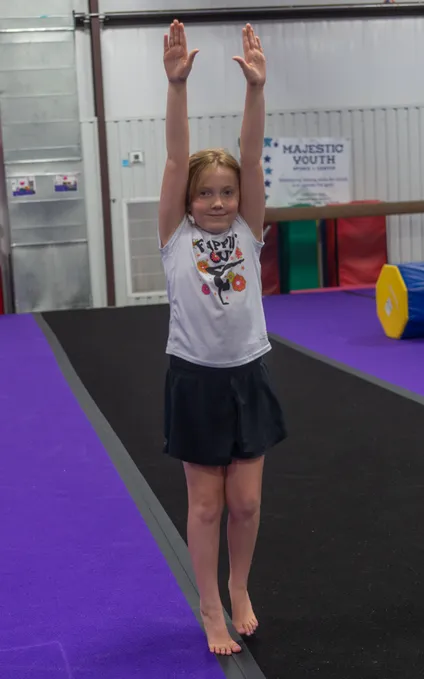 Youth cheerleading team performing synchronized routine with pom-poms