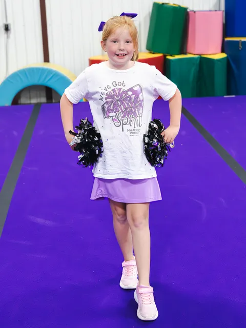 Energetic cheerleaders executing perfect synchronized routine with pom-poms and smiles