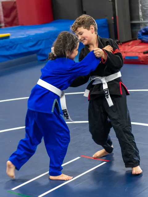 Young martial artists practicing wrestling technique with focused determination