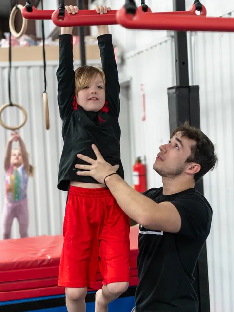 Young ninja conquering rope climb obstacle with determination and focus