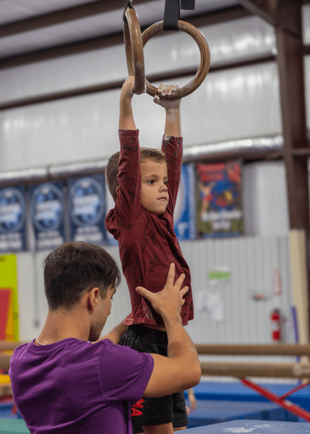 Boy gymnast training on the rings in Willis, TX
