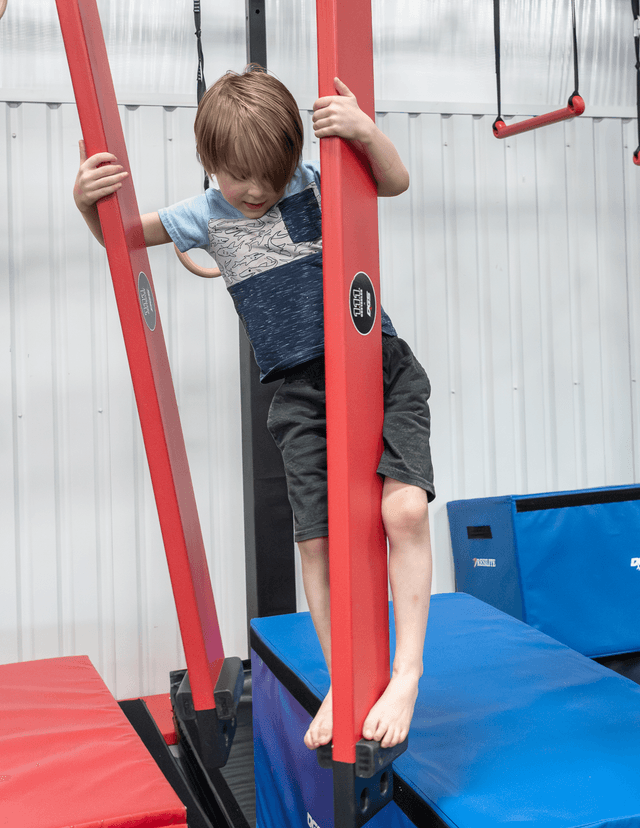 Young ninja climbing the obstacle course posts